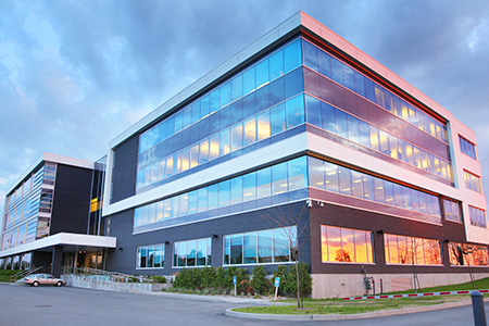 Exterior of a commercial, window covered building at sunset